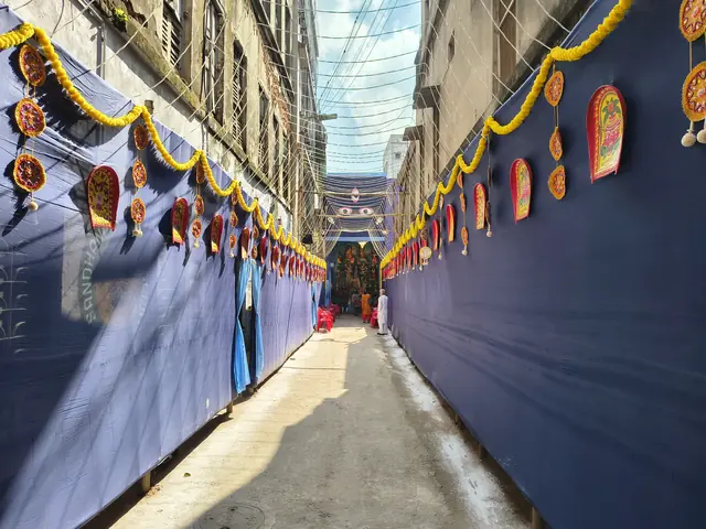 The lane, draped and decorated, on a quiet Saptami morning