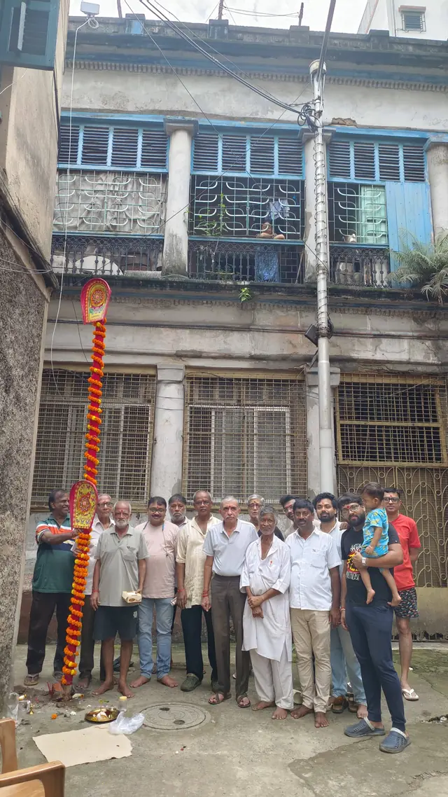 Members and neighbours gather around the khuti after the puja